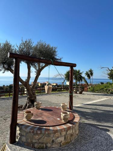 a wooden table with bowls on it next to a tree at La Casetta della Nonna in Belmonte Calabro