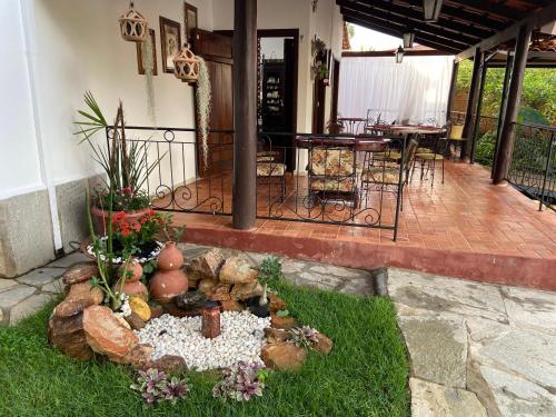 a patio with a garden with a table and chairs at Casarão Coimbra Pousada Colonial in Pirenópolis