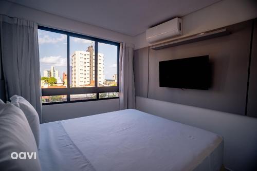 a bedroom with a bed and a large window at Flats Confortáveis em Manaíra Mindset - Qavi in Tambaú