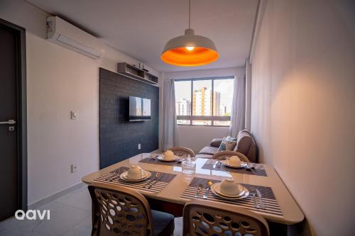 a dining table and chairs in a living room at Flats Confortáveis em Manaíra Mindset - Qavi in Tambaú