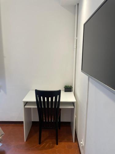 a black chair sitting at a white desk with a screen at Casa Mantovana in Mantova