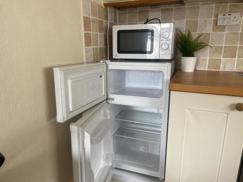 a microwave oven sitting on top of an open refrigerator at SeasideEscape-2Br-Sleeps4-Parking-PetsOK-Fireplace in Bridlington