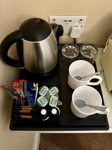 a counter top with a coffee pot and utensils at The Crescent York in York