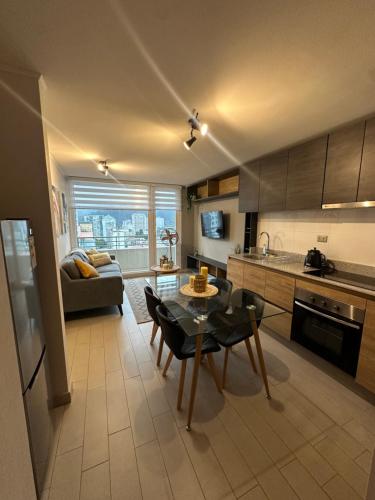 a kitchen and living room with a table and a couch at Céntrico y hermoso in Concepción