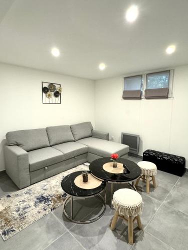 un salon avec un canapé et deux tables dans l'établissement Duplex chaleureux, à Livry-Gargan