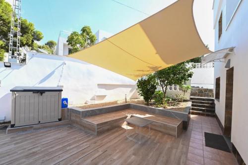 a patio with a table and a yellow umbrella at Etonnante Villa Carrio à Calpe by LG Home in Calpe