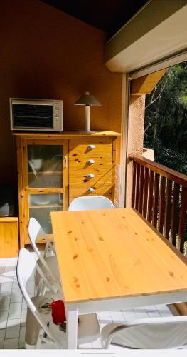 d'un balcon avec une table et des chaises et un four micro-ondes. dans l'établissement Les Cystes, à Sanary-sur-Mer