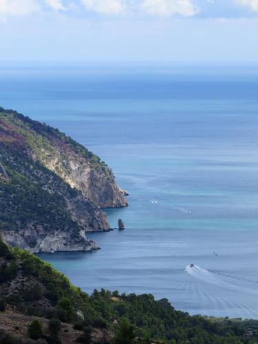 a boat in the water next to a mountain at B&B I Due Orizzonti in Mattinata