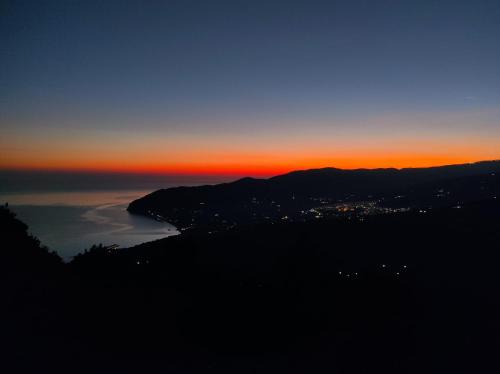 a view of the ocean at sunset with a city at B&B I Due Orizzonti in Mattinata