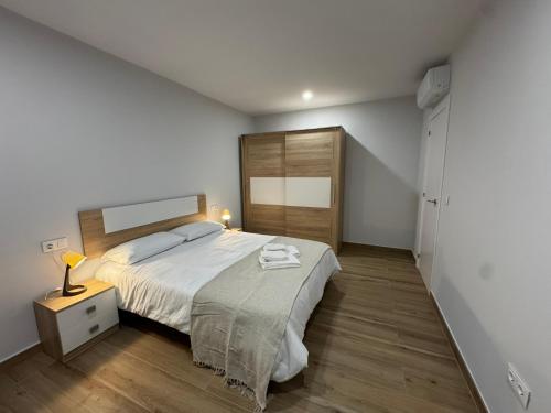 a bedroom with a large bed and a wooden floor at Apartamentos La Paz in Ibi