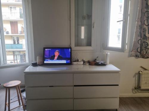 un ordinateur portable assis au-dessus d'une commode dans l'établissement Nice stay close to paris, à Aubervilliers