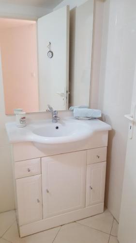 une salle de bain avec un lavabo blanc et un miroir dans l'établissement En plein coeur du Vieux Nice, à Nice