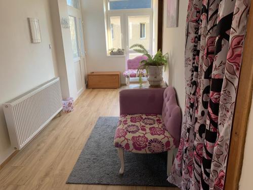 a living room with a purple chair and a table at Dovolenkový dom v centre in Slovenská ľupča
