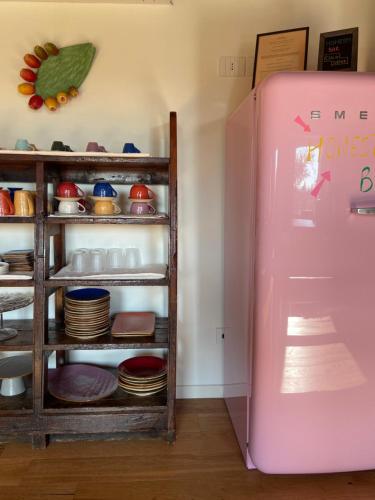 a pink refrigerator in a room with dishes at Residenza Vesentini in Pastrengo