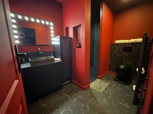 a red bathroom with a sink and a mirror at LE CINÉ-ROOM, T2, Netflix, Prime, Hyper-centre in Mâcon