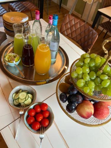 two plates of fruit on a table with glasses of juice at Residenza Vesentini in Pastrengo