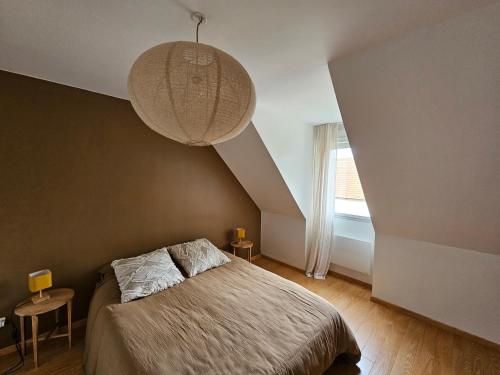 une chambre avec un lit et un lustre dans l'établissement CAP GRIS NEZ Maison 6 pers, à Audinghen