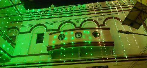 a green room with a clock on the side of a building at Topper home stay in Varanasi