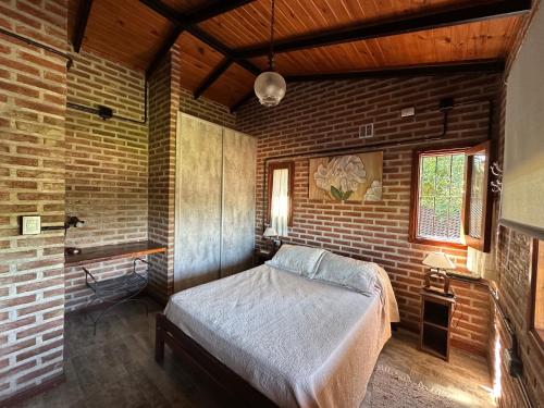 a bedroom with a bed and a brick wall at Valle Verde in Villa Giardino