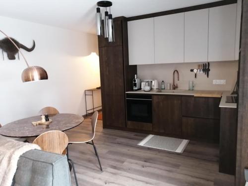 a kitchen with a table and a dining room at Le SANTA in Sainte-Foy-Tarentaise