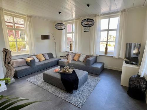 a living room with two couches and a tv at Rhynhoven Lodge in Hazerswoude-Rijndijk