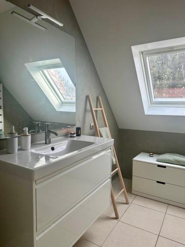 La salle de bains est pourvue d'un lavabo et d'une lucarne. dans l'établissement Maison de charme au calme, à Fouesnant