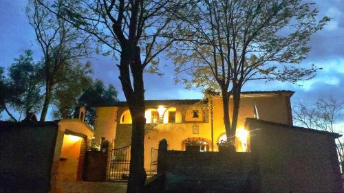a house with lights on the side of it at Podere Rinascidentro in Asciano