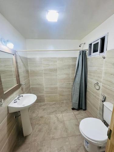 a bathroom with a white sink and a toilet at Cabañas Boutique La Soñada in Fiambalá