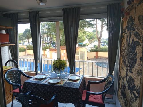 a table and chairs in a room with a window at joli studio cabine 4 personnes à 300 m de la plage in Argelès-sur-Mer