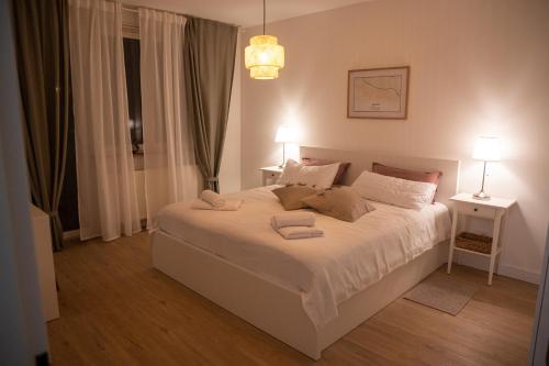 a bedroom with a white bed with two towels on it at Apartman Esseg - Luxury Living in Historic Esseg - SELF CHECK IN in Osijek