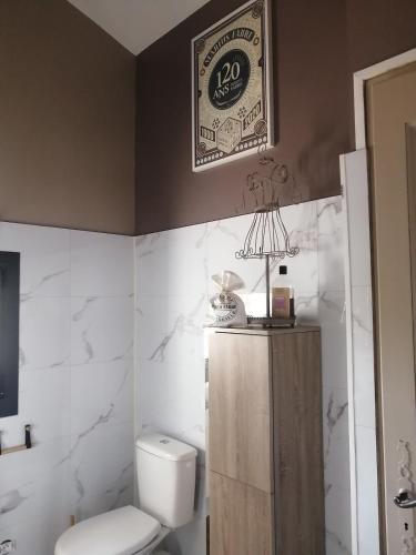 une salle de bain avec toilettes et un tableau au mur dans l'établissement villa climatisée piscine cuisine été alpilles provence, à Eyguières
