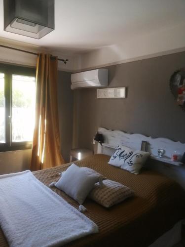 une chambre avec un lit avec des oreillers et une fenêtre dans l'établissement villa climatisée piscine cuisine été alpilles provence, à Eyguières