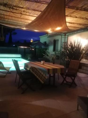 - une table et des chaises sur la terrasse la nuit dans l'établissement villa climatisée piscine cuisine été alpilles provence, à Eyguières