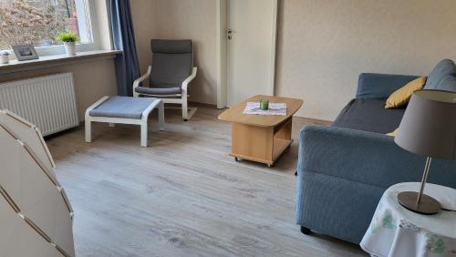 a living room with a blue couch and a table at 2 Zi-Appartment mit Gartennutzung in Brühl