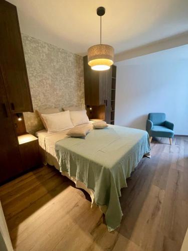 une chambre avec un lit et une chaise bleue dans l'établissement Le SANTA, à Sainte-Foy-Tarentaise