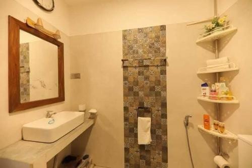 a bathroom with a sink and a mirror at Villa Panthuja in Unawatuna