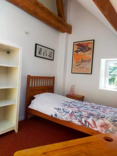 une chambre avec un lit et une étagère dans l'établissement Duplex des Chais parking et jardin, à Saint-Jean-de-la-Ruelle