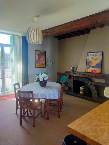un salon avec une table et des chaises et une cheminée dans l'établissement Duplex des Chais parking et jardin, à Saint-Jean-de-la-Ruelle