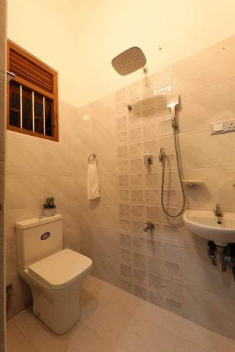a bathroom with a toilet and a shower and a sink at Villa Panthuja in Unawatuna