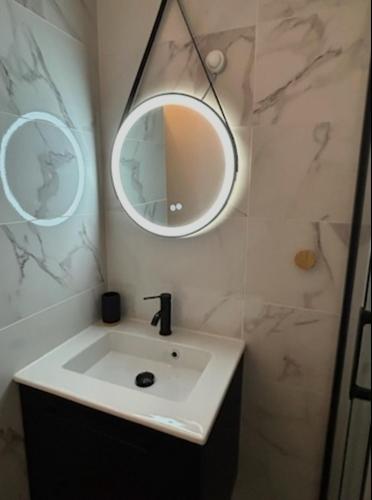 une salle de bain avec un lavabo et un miroir dans l'établissement Wallis2, à Sausset-les-Pins