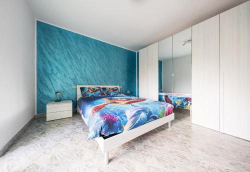 a bedroom with a bed with a blue wall at Bosa Mare & Relax in Bosa Marina