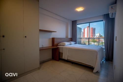 a hotel room with a bed and a window at Flats Confortáveis em Manaíra Mindset - Qavi in Tambaú
