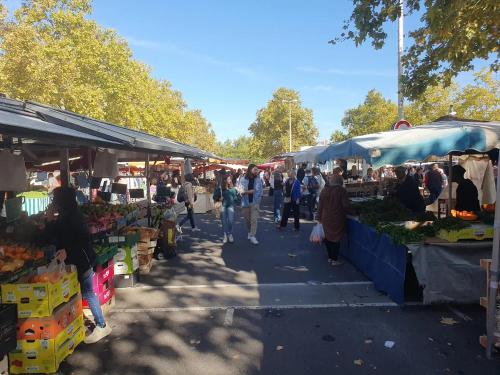un gruppo di persone che camminano in un mercato all'aperto di Appartement charmant proche Gare a Tours
