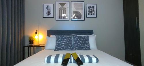 a bedroom with a bed with four pictures on the wall at Santorini Condotel in Manila