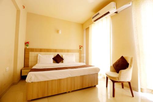 a bedroom with a large bed and a chair at Tabtrips Bhakti Residency in Vrindāvan