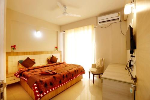 a bedroom with a bed and a television in it at Tabtrips Bhakti Residency in Vrindāvan