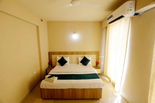 a bedroom with a bed in a room with a window at Tabtrips Bhakti Residency in Vrindāvan