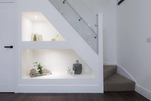 a white staircase with a shelf under the stairs at 5 Stockland Street in Caerphilly