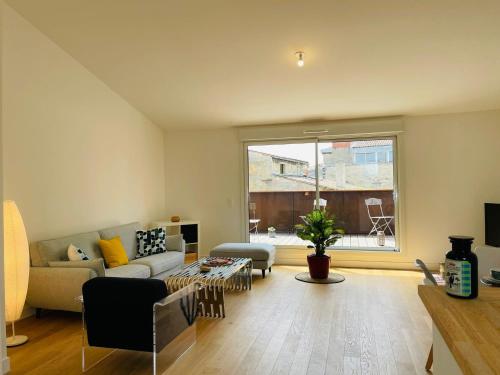 un salon avec un canapé et une table dans l'établissement Splendide duplex Saint-Michel - Terrasse & Garage - 4,91 sur 5 avec 90 avis, à Bordeaux