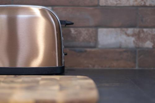 a metal toaster sitting on a counter next to a brick wall at 5 Stockland Street in Caerphilly